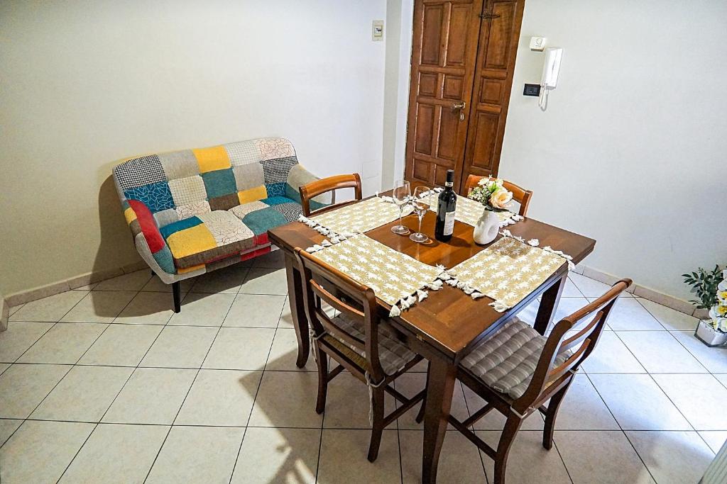 a dining room with a table and a couch at Terrazza di Alfieri - Alloggio con terrazza privata nel centro di Asti in Asti