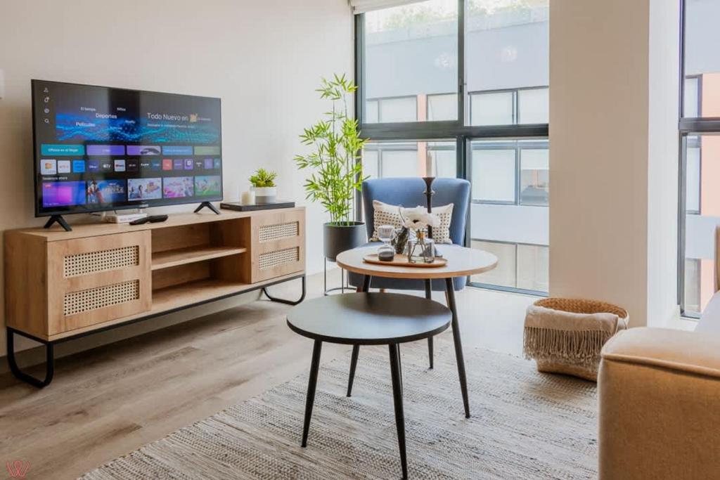 a living room with a tv and a table and a chair at Appealing 1BR Comfy apartment in Surco in Lima