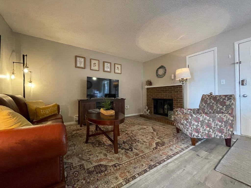 a living room with a couch and a chair and a fireplace at Campus West Nest - King Bed, Walk to CSU in Fort Collins