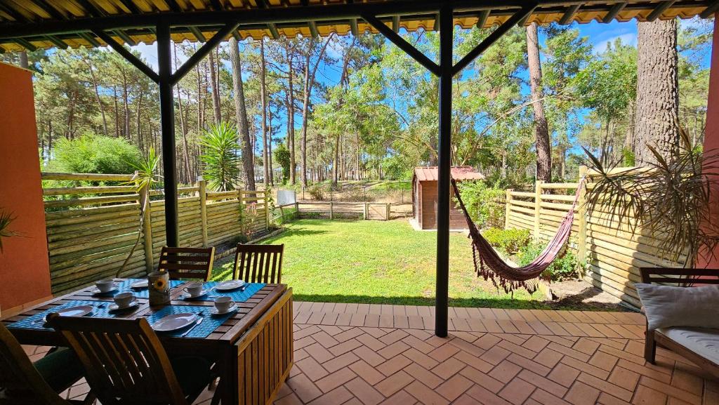 a patio with a hammock and a table and chairs at Apartamento Herdade Aroeira, Praia, Golfe perto Lisboa in Almada