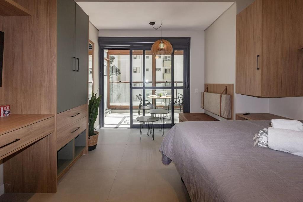 a bedroom with a bed and a table in a room at Refúgio Moderno no Campo Belo NOVO in Sao Paulo