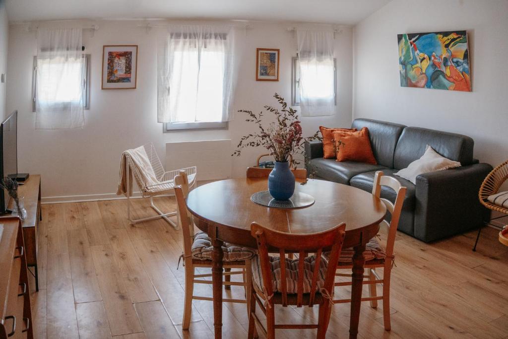 a living room with a table and a couch at Charmant appartement, calme, climatisé, centre historique in Avignon
