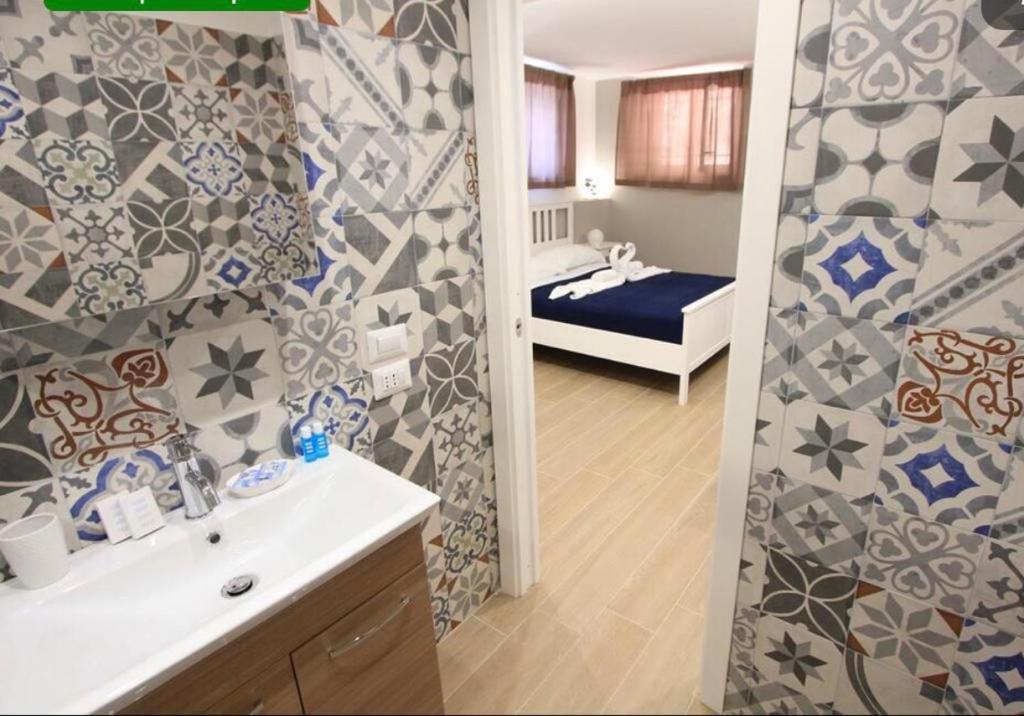a bathroom with a sink and a shower with a bed at Sapore di Mare al Duomo in Gaeta