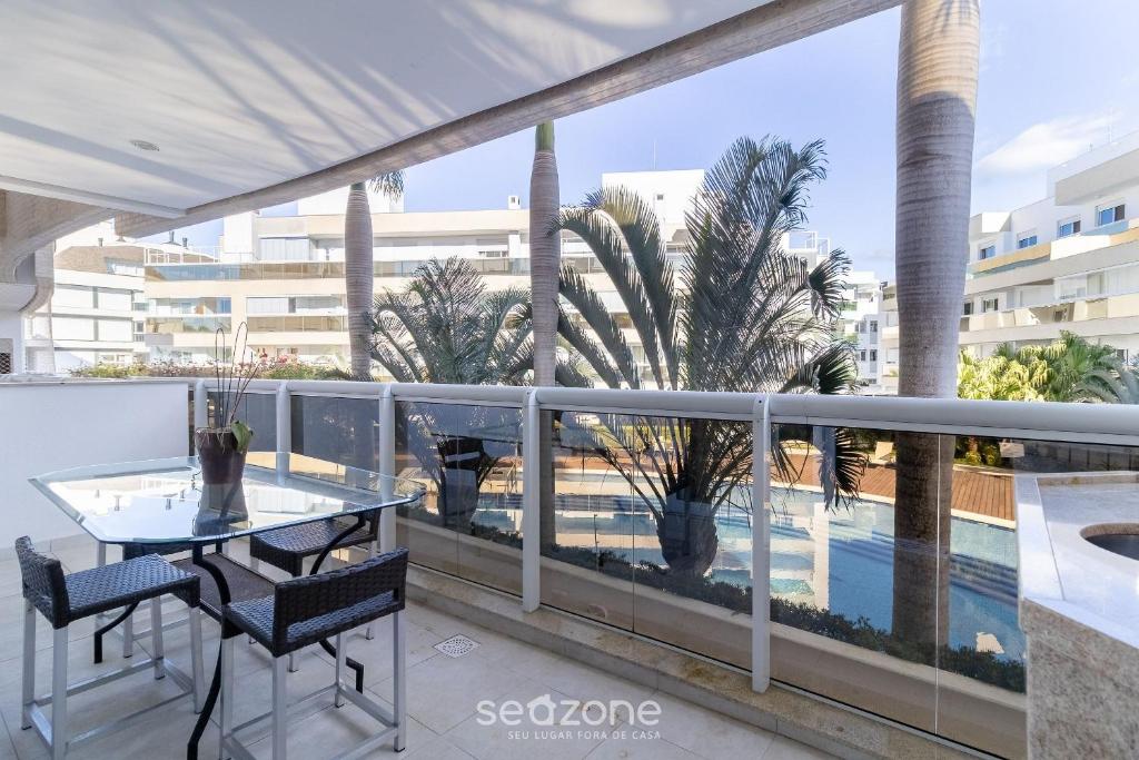 a balcony with a table and chairs and a swimming pool at Apto c/ Churrasqueira em Cond. c/ Piscina BRI0102 in Florianópolis
