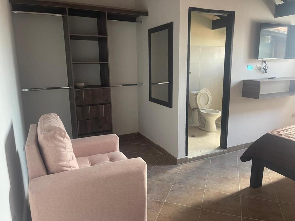 a living room with a chair and a bathroom at Extraordinaria Casa con Piscina in Mérida