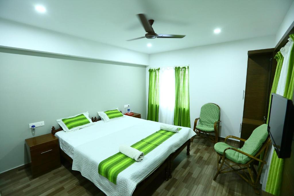 1 dormitorio con 1 cama y TV de pantalla plana en Mistygreen Homestay Thekkady, en Thekkady