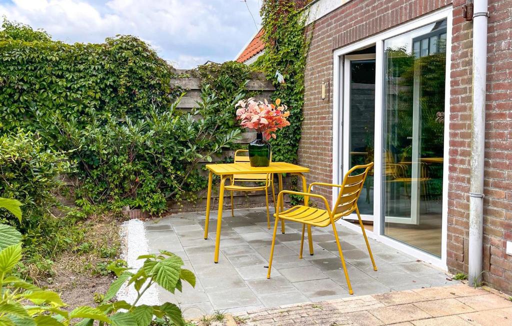 una mesa amarilla y sillas en un patio en Cozy Home In Bergen Aan Zee With Wifi, en Bergen aan Zee