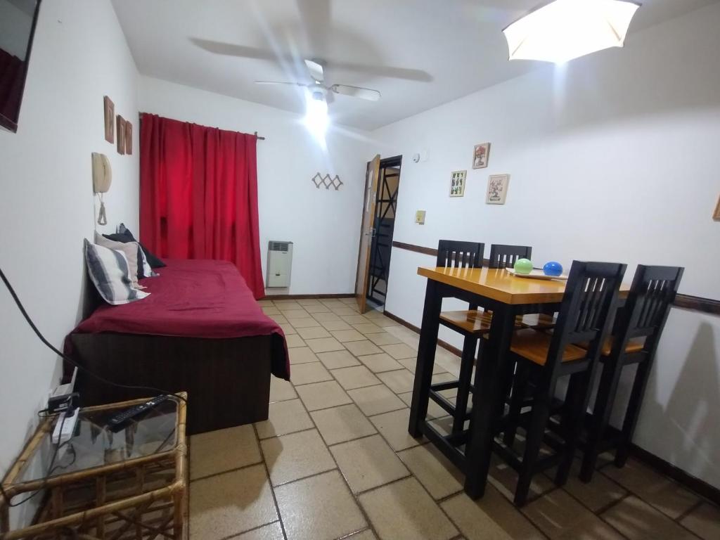 a room with a bed and a table and chairs at Altos Mendoza Av España in Mendoza