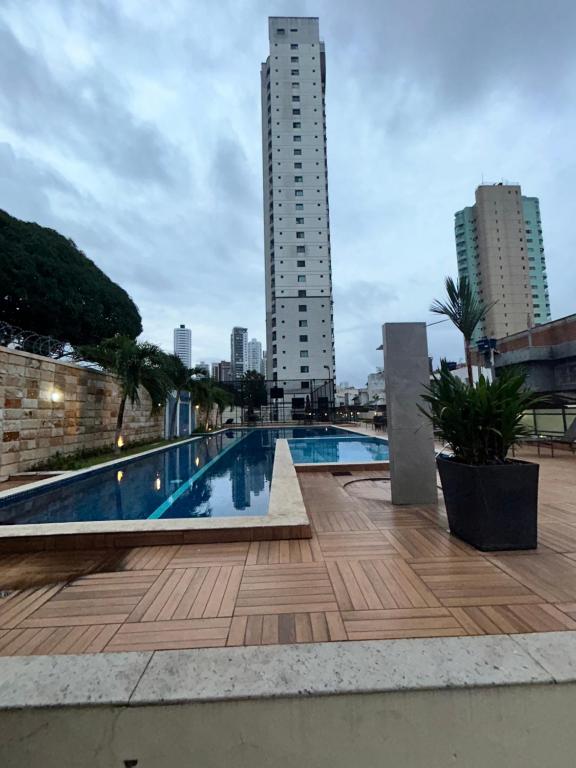 a swimming pool with two tall buildings in the background at Apartamento de Luxo in Belém