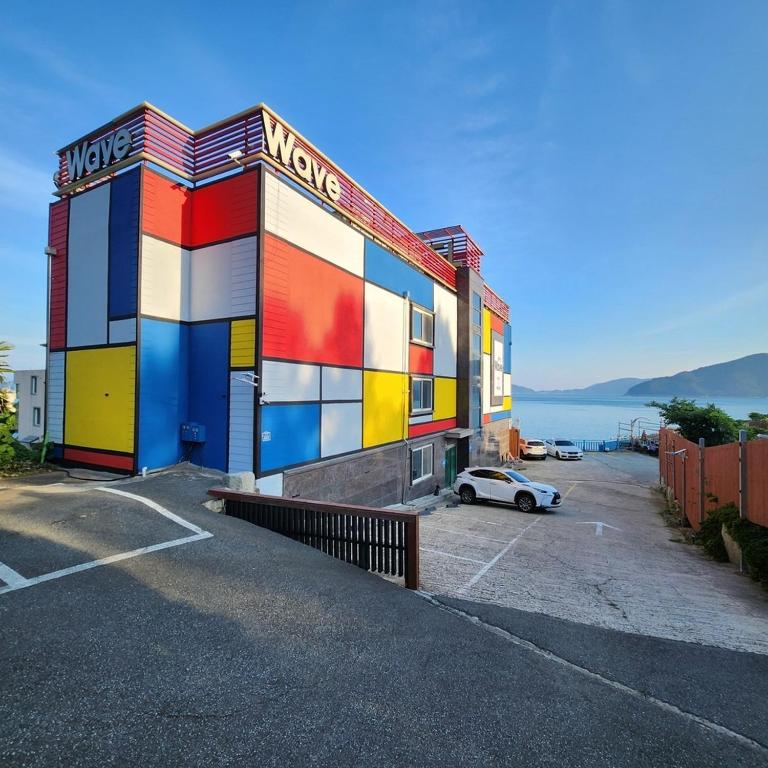 a colorful building with a car parked in front of it at Geoje Wave Hotel & Pension in Geoje