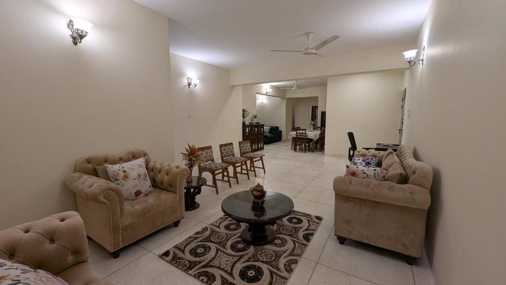 a living room with couches and chairs and a table at Room in Uttara Sector 3 Apartment in Bāiljuri