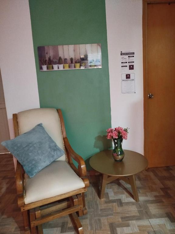 a room with a chair and a table with a vase of flowers at La casita de Johisfress in Cartagena de Indias