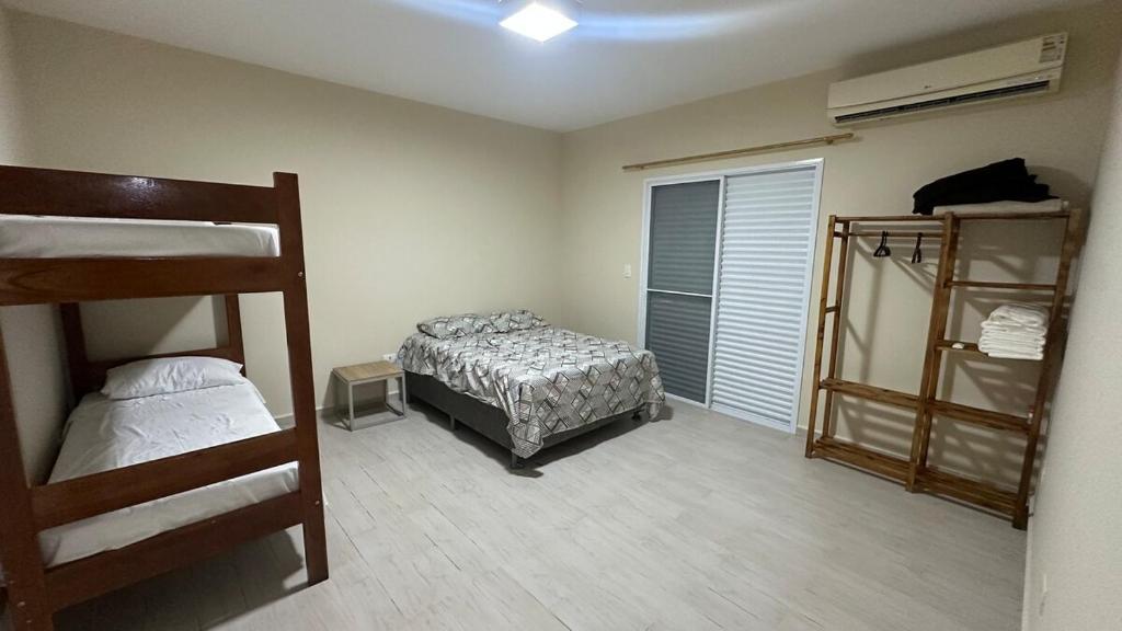 a bedroom with two bunk beds and a window at Casa em Cananéia! in Cananéia