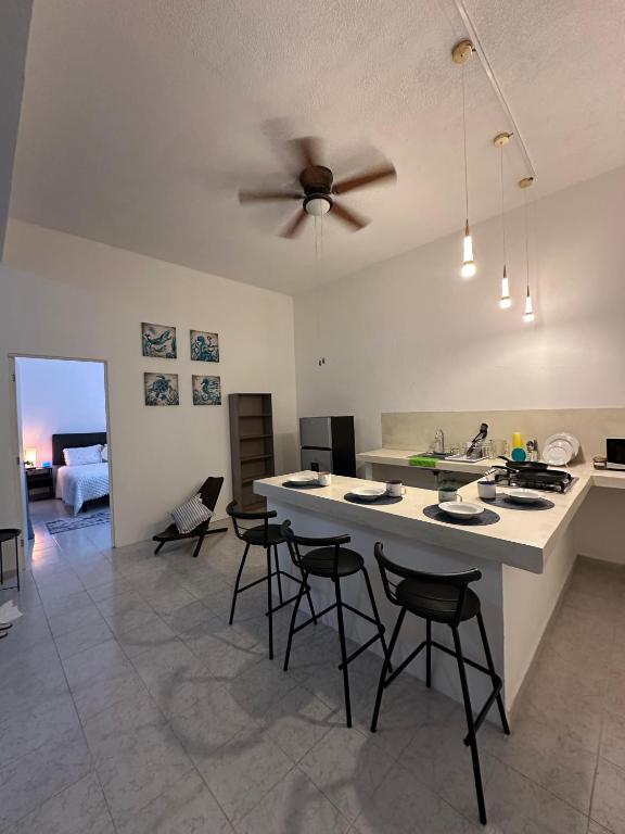 a kitchen and living room with a ceiling fan at Azul de sal in Cancún