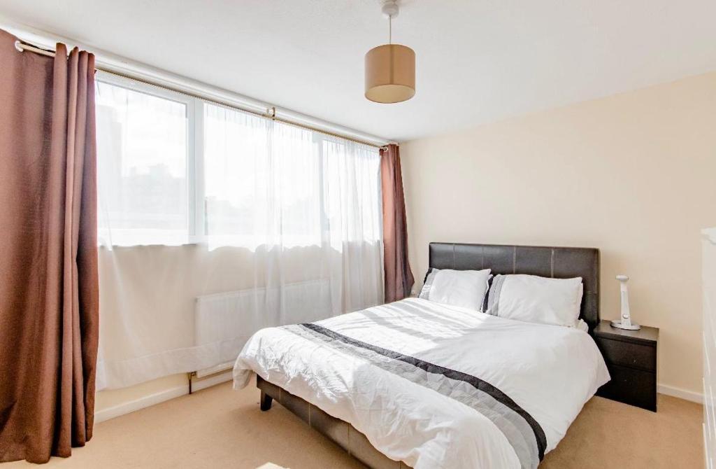 Private Beautiful Cozy Double Bedroom in London في South Norwood: غرفة نوم بها سرير ونافذة كبيرة