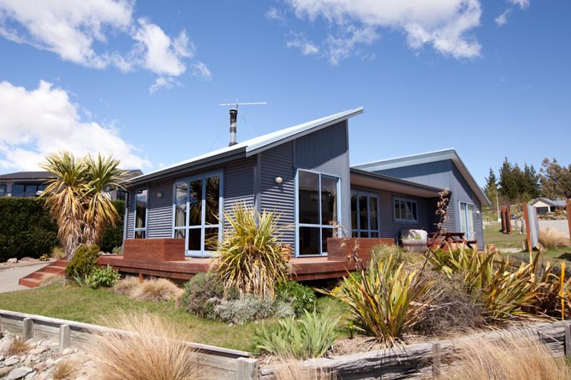 a blue house with a porch on a yard at Pukeko Palace - Lake Tekapo in Lake Tekapo