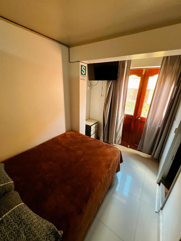 a small bedroom with a bed and a window at Huamanga plaza in Ayacucho