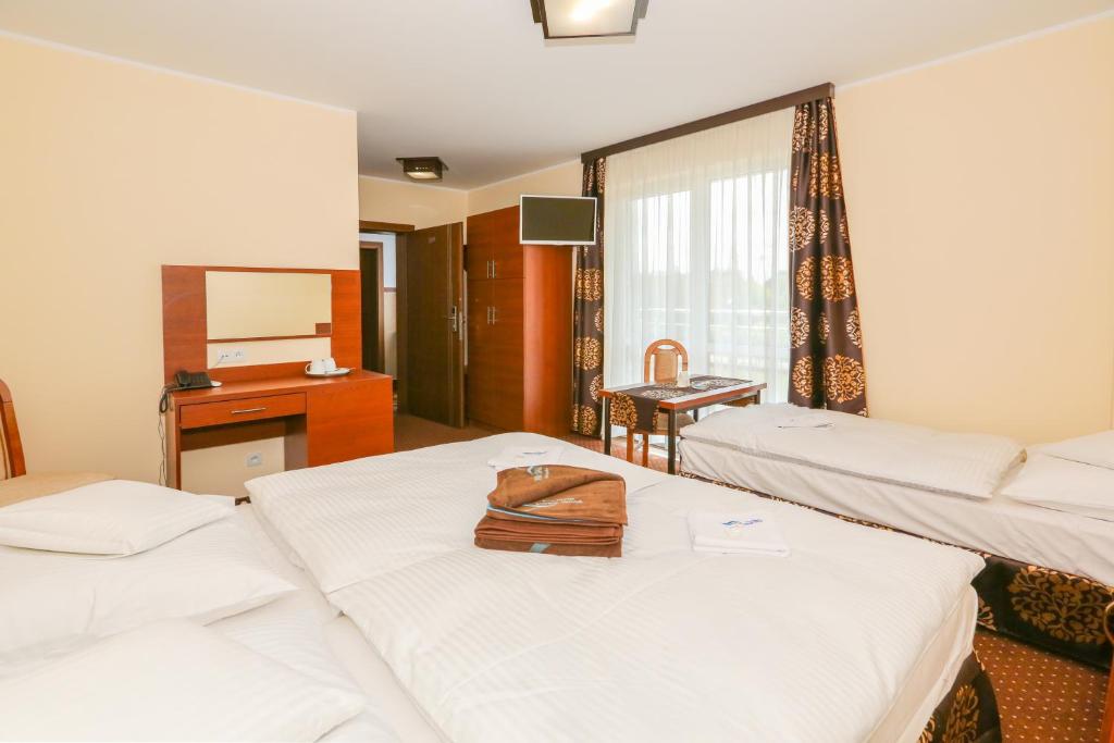 a hotel room with two beds with a purse on top at Willa Saga in Władysławowo