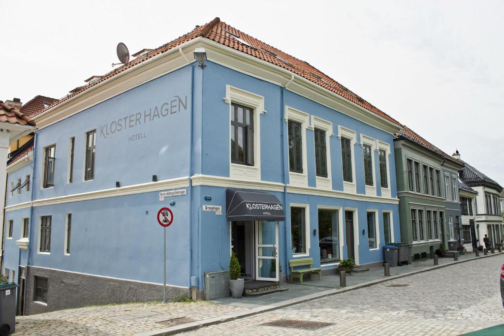 un edificio blu sul lato di una strada di Klosterhagen Hotel a Bergen