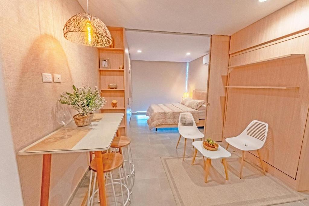 Una pequeña habitación con una cama, una mesa y sillas. en Nuevo y lujoso Aparta suite en el exclusivo sector de playa salguero Santa Marta, en Santa Marta