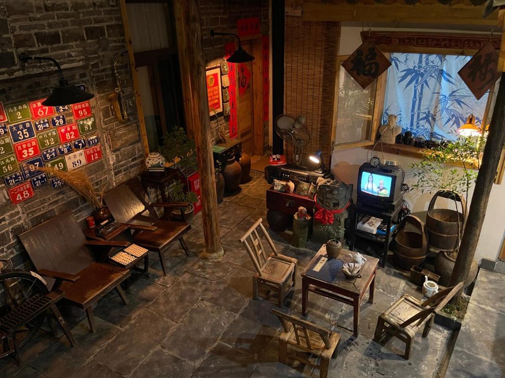 凤凰Fenghuang Ancient Town Persimmon Courtyard B&B的享有带椅子和电视的客厅的顶部景色。