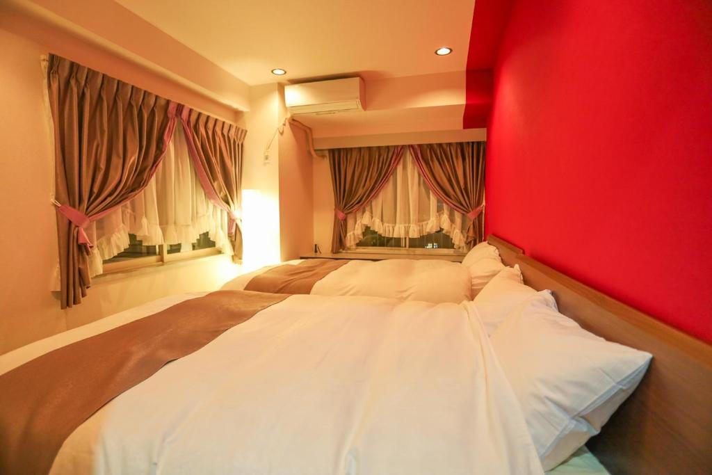 名古屋市にあるFushimi Yokkusu Building 10F - Vacation STAY 16301の赤い壁のベッドルーム1室(大型ベッド1台付)