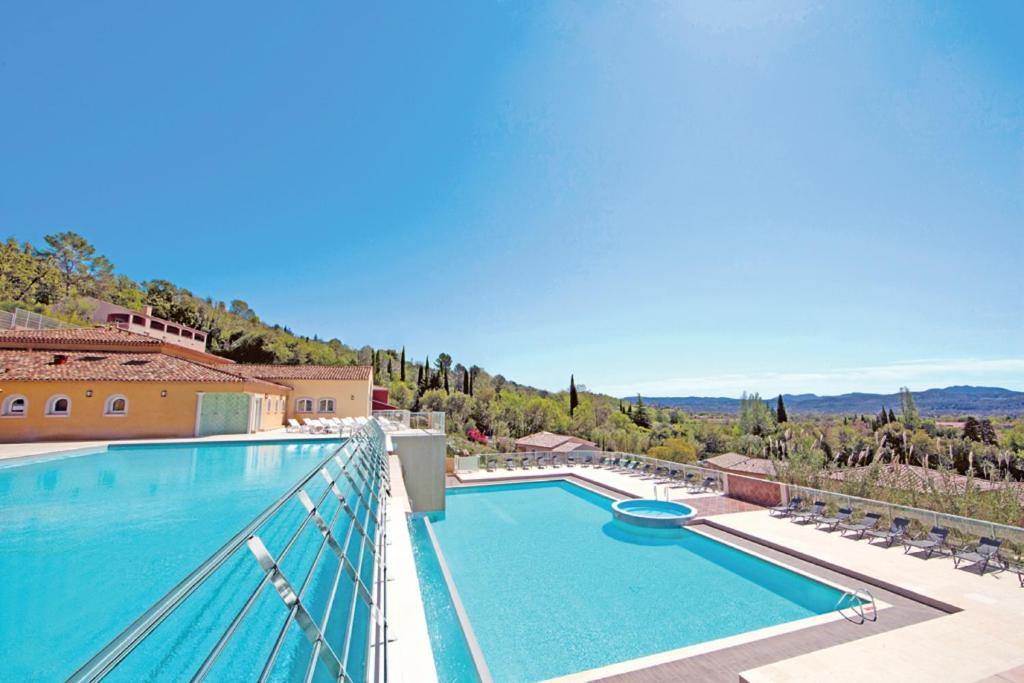 un balcón con una gran piscina en la parte superior de una casa en Vacancéole – Le Domaine de Camiole, en Callian