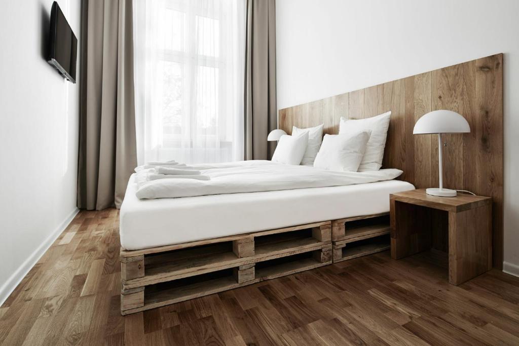 a bedroom with a large bed with a wooden headboard at CityNest Apartments in Kraków