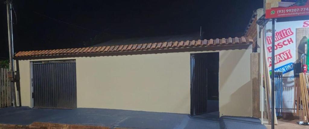 a white garage with a gate and a building at Casa 3 quartos em Juruti in Juruti
