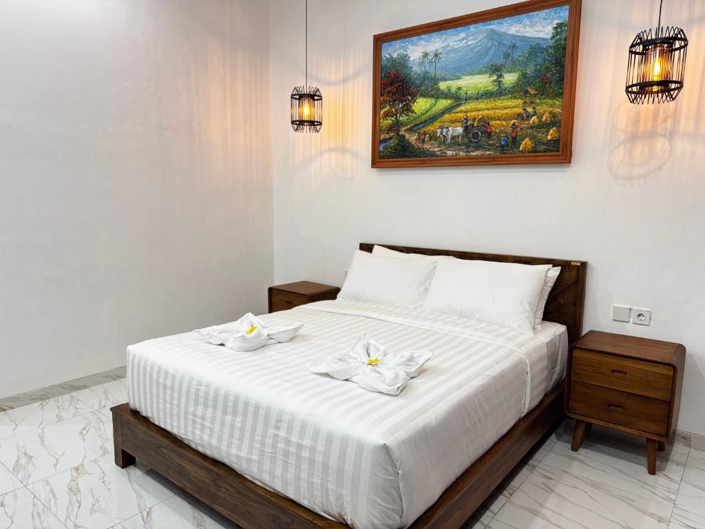 a bedroom with a bed with two white towels on it at Dé Kamala Bali in Nusa Dua
