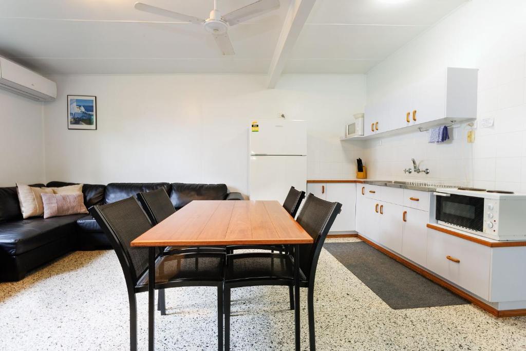 a kitchen and dining room with a table and chairs at Koala Lodge Unit 3 in Iluka