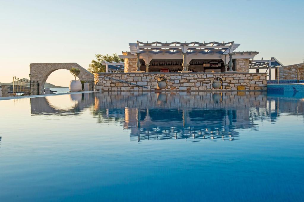 a building sitting on top of a body of water at Contaratos Beach Hotel in Naousa
