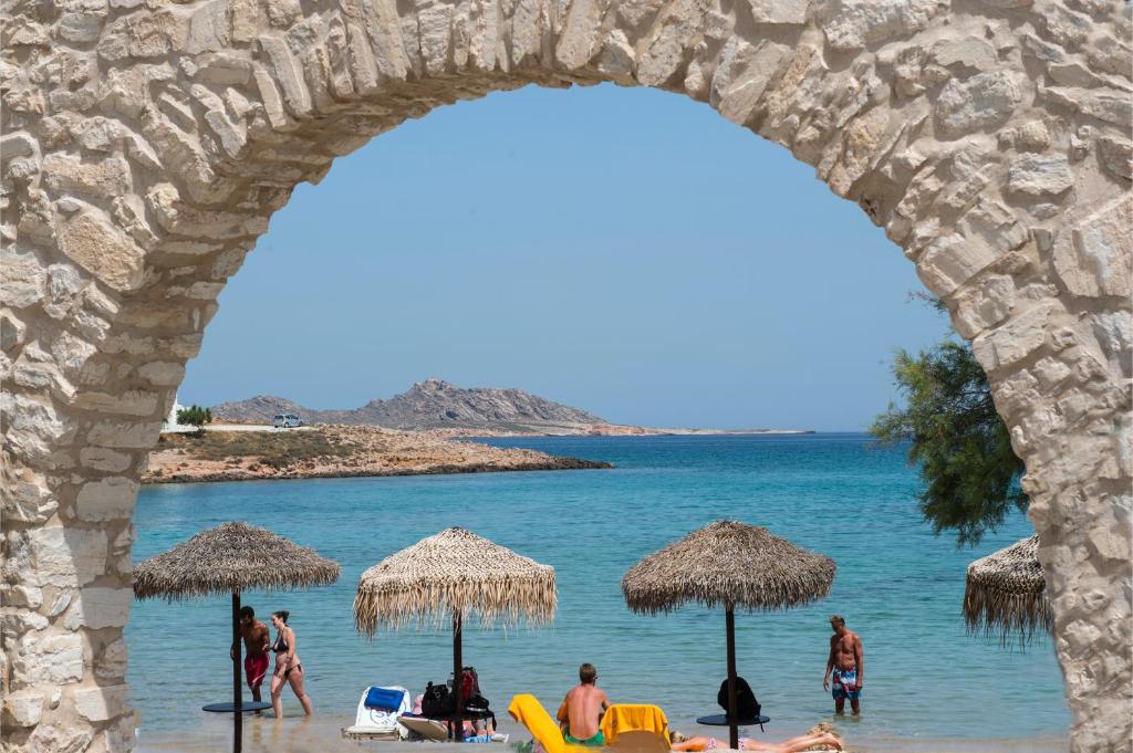 a group of people on a beach with umbrellas at Contaratos Beach Hotel in Naousa