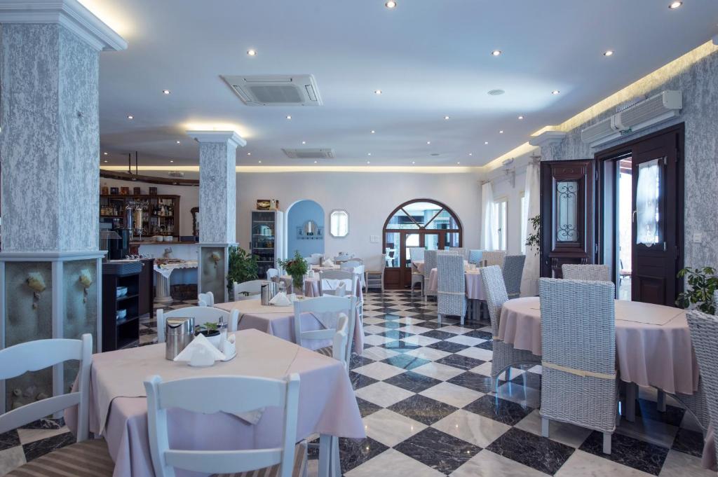 a restaurant with tables and chairs in a room at Contaratos Beach Hotel in Naousa