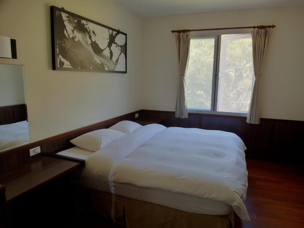 a bedroom with a large bed and a window at Tea Cloud B&amp;B in Leye