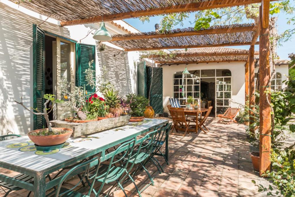 eine Terrasse mit einem Tisch, Stühlen und einer Pergola in der Unterkunft B&B La casa di Pippinitto in Santa Venerina