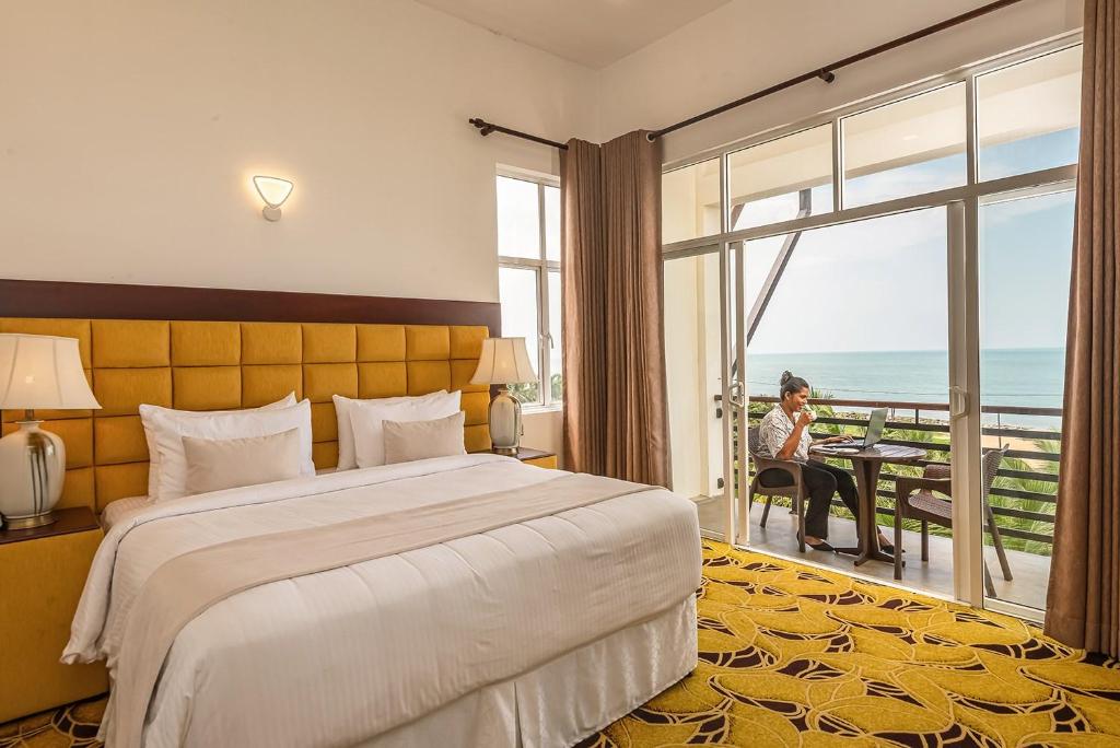 a hotel room with a bed and a view of the ocean at Beverly Beach Hotel & Transit in Negombo