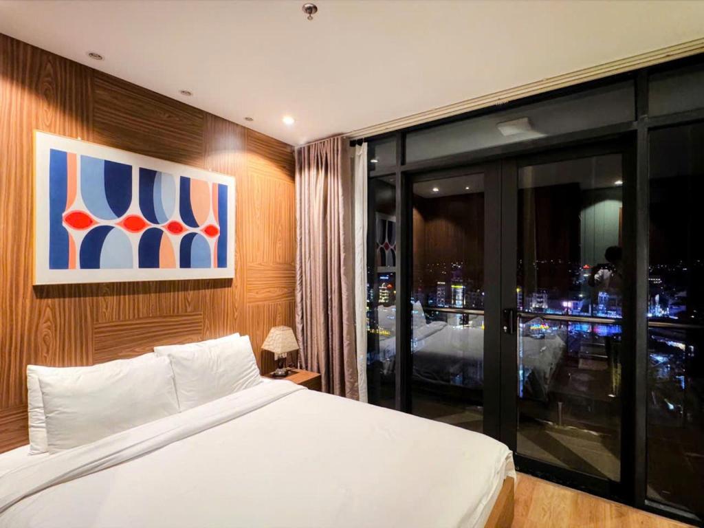 a bedroom with a bed and a view of a city at Condo 2BR City Center - The 2nd Home in Da Lat