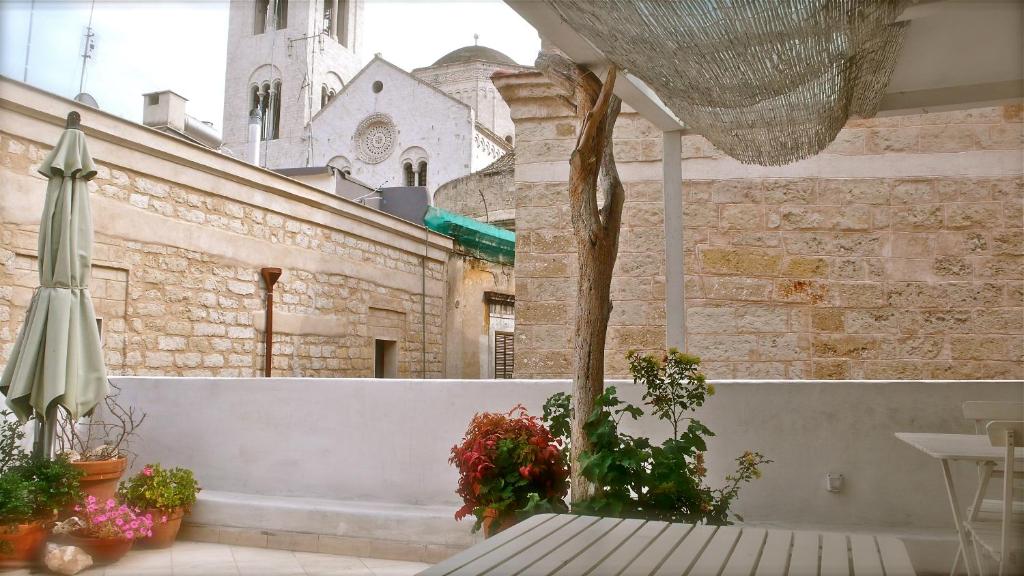 um quarto com uma mesa e uma árvore e um edifício em Casa Odegitria em Bari