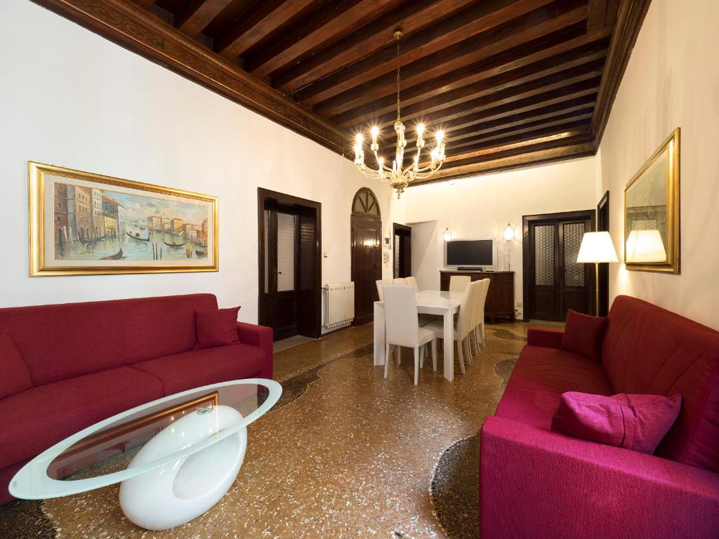 una sala de estar con 2 sofás rojos y una mesa. en San Marco Schiavoni apartments, en Venecia