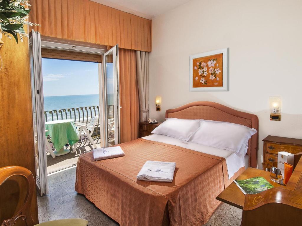 1 Schlafzimmer mit einem Bett und einem Balkon mit Meerblick in der Unterkunft Hotel Dea in Milano Marittima