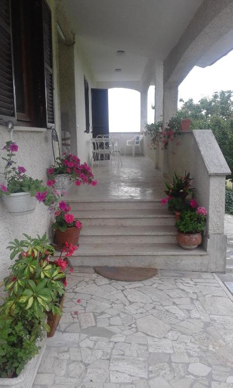 a porch of a house with potted plants and flowers at Deliziosa Villa Panoramica in Campagnano di Roma