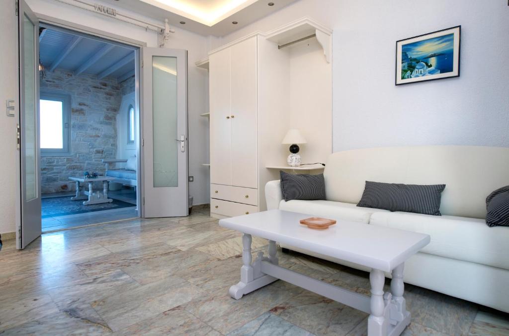 a living room with a white couch and a table at Contaratos Beach Hotel in Naousa