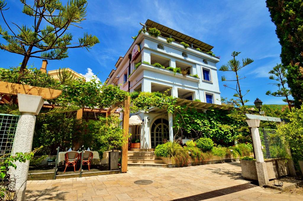 a large white house with plants on it at Villa Velzon Guesthouse in Budva