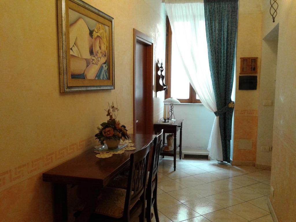 a dining room with a table and a picture on the wall at B&B al Corso in Tarquinia