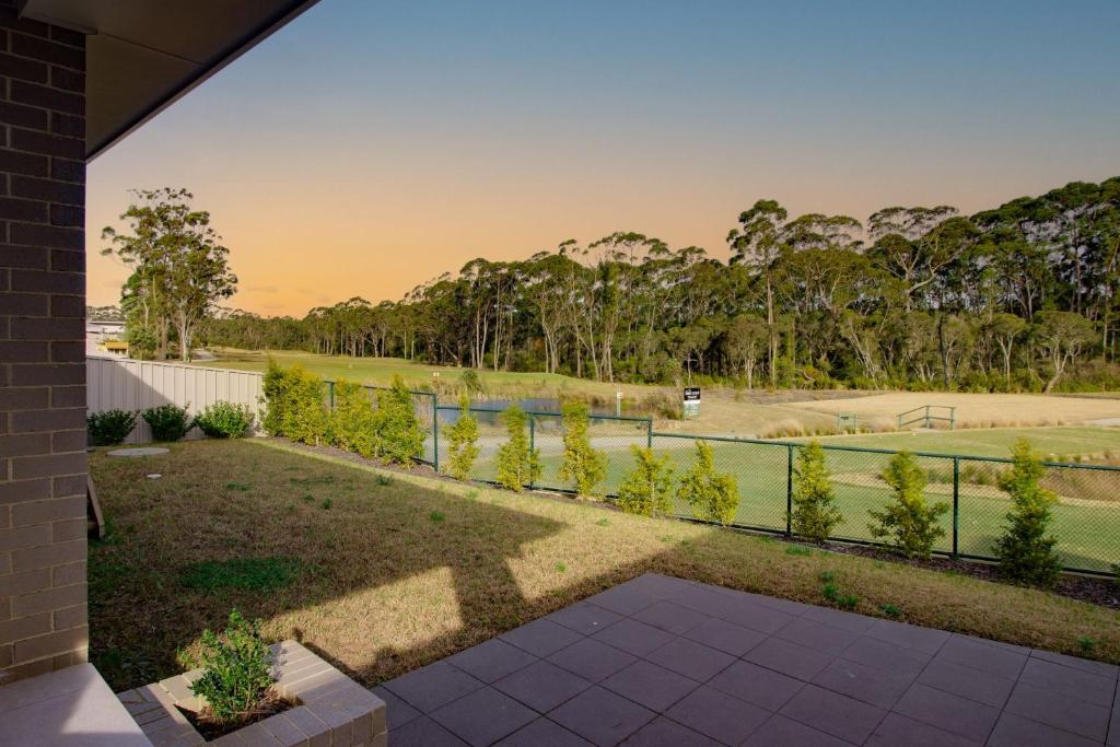 Una vista de un campo de golf desde el patio trasero de una casa. en Serenity on the Green, en Sussex Inlet