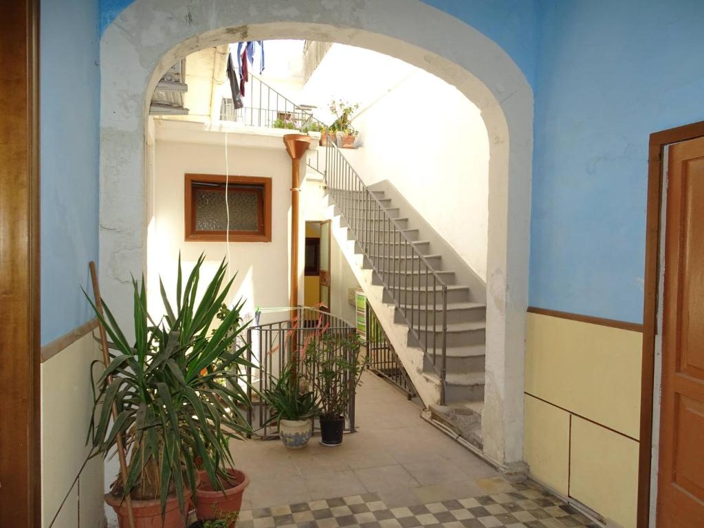 een boog met trappen in een gebouw met potplanten bij Palazzo Iargia in Canicattini Bagni