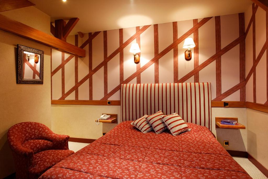 a bedroom with a red bed and a chair at Logis Hôtel restaurant LE MEDICIS in Blois