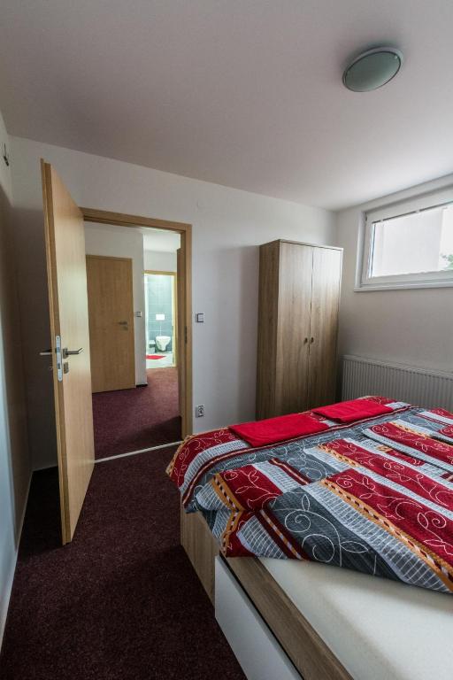 sypialnia z łóżkiem z czerwonym kocem w obiekcie Apartmány Vilma w mieście Lednice