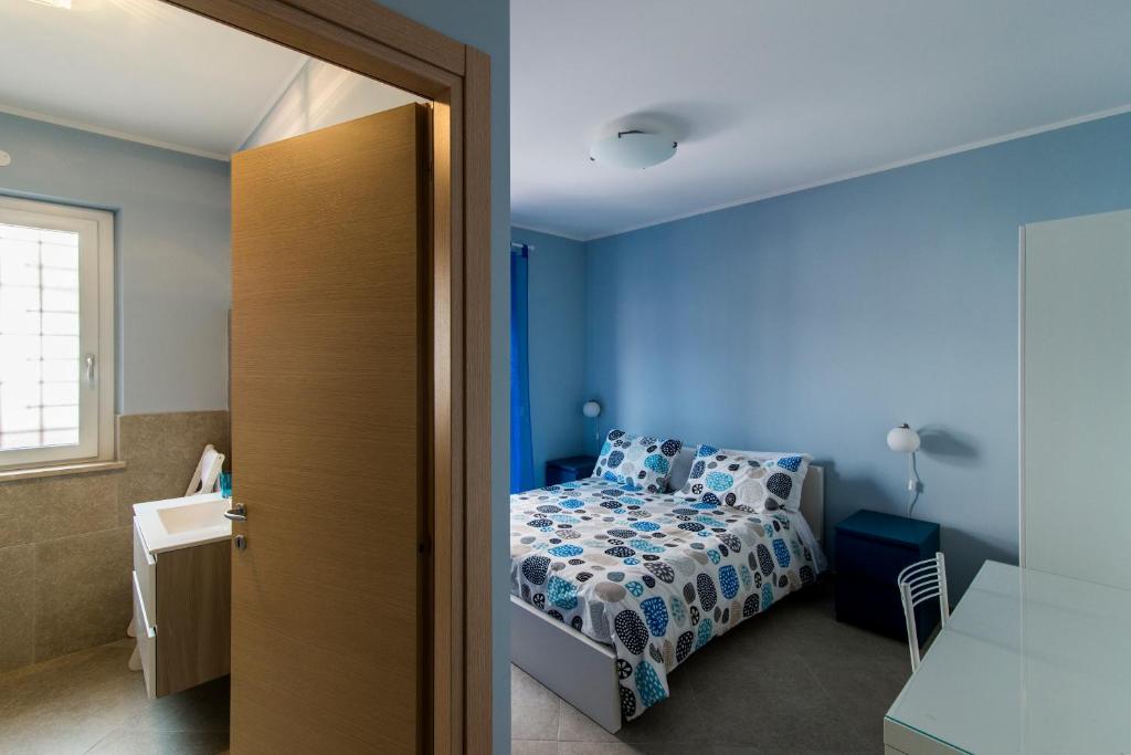 ラディスポリにあるGuest House Roma Expressの青い壁のベッドルーム1室(ベッド1台付)